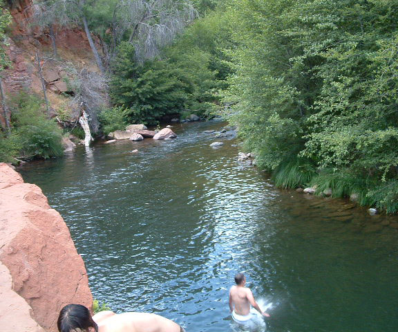 Swimmer jumping off rock into Oak Creek